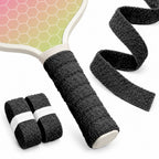 Black T1 towel overgrip on a paddle handle beside two rolls and an unrolled textile strip.
